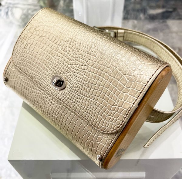 Beltbag σε χρυσό δέρμα εφέ κροκό με ξύλινα πλαινά και μεταλικές λεπτομέρειες.